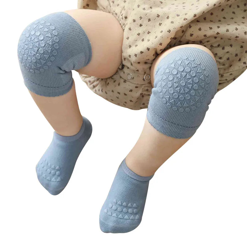 Baby wearing blue anti-slip knee pads and socks while crawling